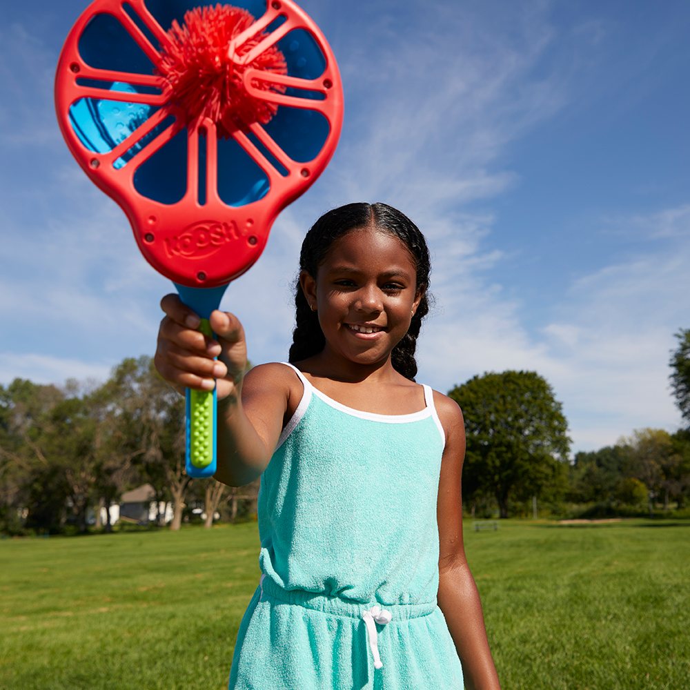 Girl holding a Koosh Flix Stix with a ball in the pocket
