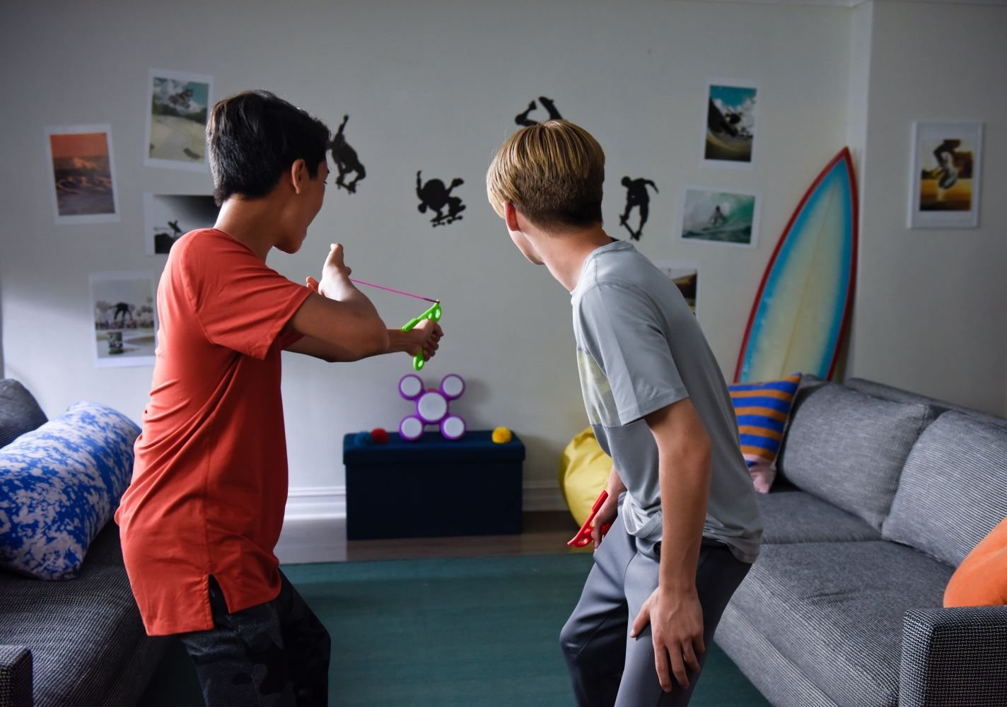 Two kids playing Koosh Sharp Shot in a living room